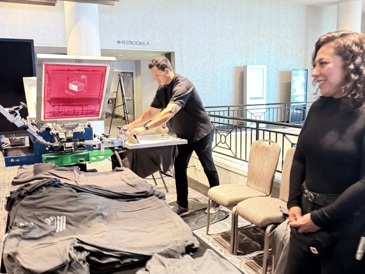 Guest laughing next to the press as shirts come off at a hotel event