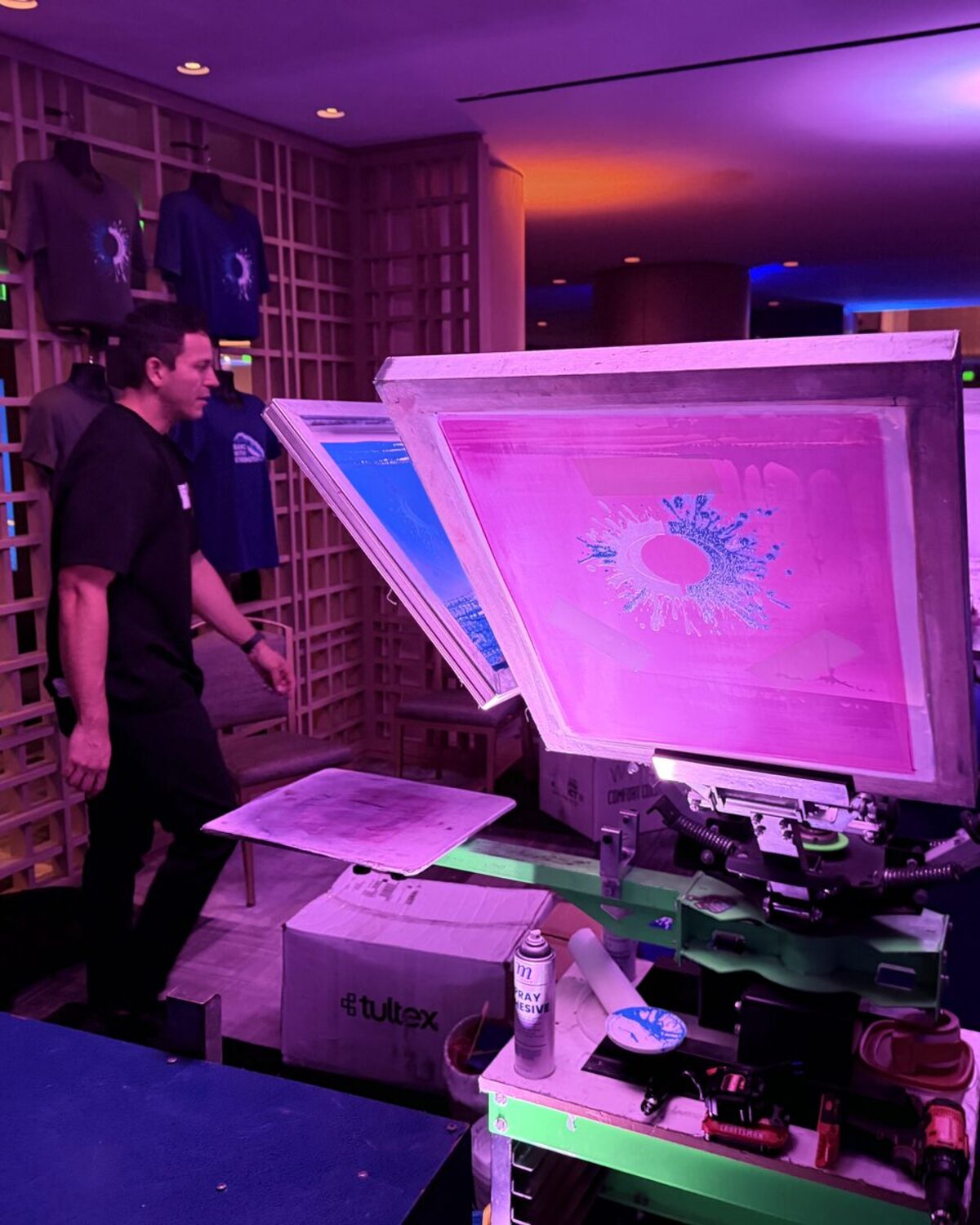 Pink screen glowing on the press at an evening party print station